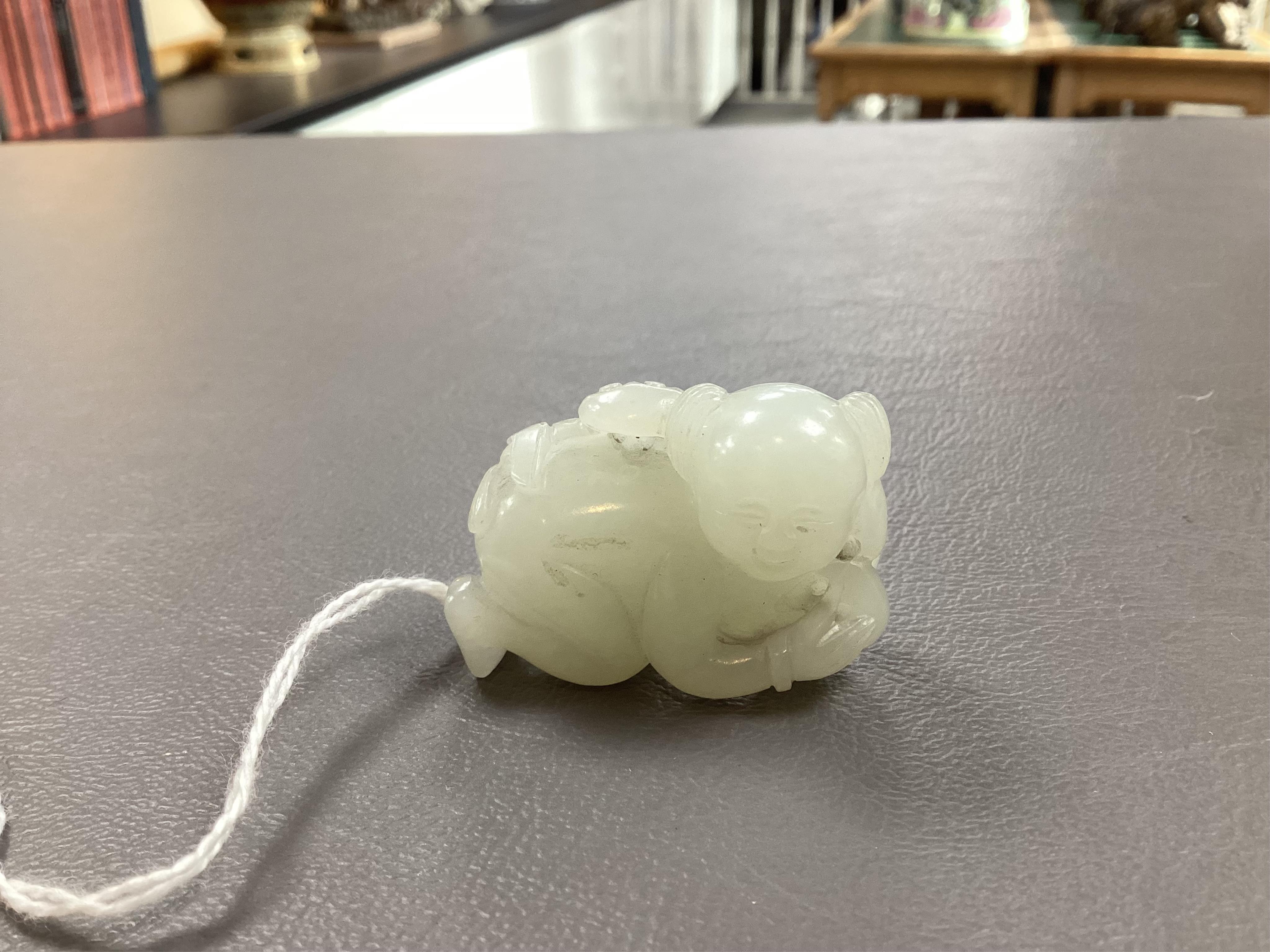 A Chinese white jade figure of a crouching boy, 19th/20th century